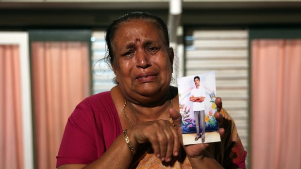 Tamil woman Tangaraja Rajeshwari in 2013 with a photo of her son who disappeared during the final stages of Sri Lanka's civil war.