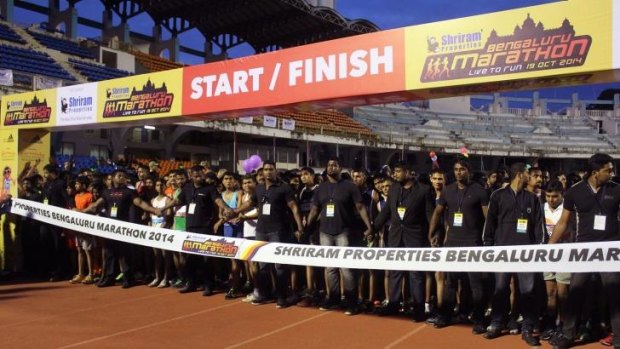 Safety first: Security guards form a human chain in front of participants of the Bengaluru marathon.