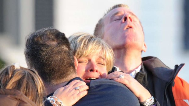 Grief overwhelms a family outside the Sandy Hook elementary school in Newtown, Connecticut.