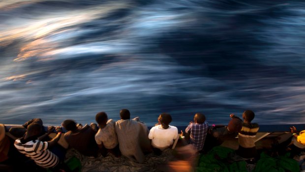 Migrants and refugees stand on the deck of the vessel Golfo Azzurro after being rescued by Spanish NGO Proactiva Open Arms workers on the Mediterranean Sea on June 16, 2017. 