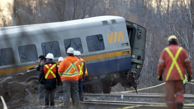 Three dead ... rescue workers examine the passenger train in Burlington, Ontario.