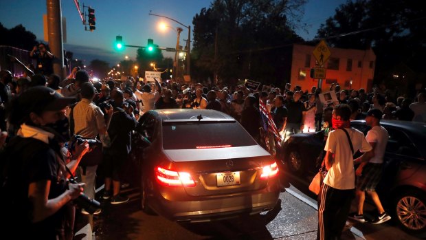 Protesters surround a car as they march in the street on Saturday in response to a not guilty verdict in the trial of former St Louis police officer Jason Stockley.