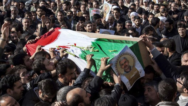 Iranian mourners carry the flag draped coffin of Hassan Shateri in Tehran.