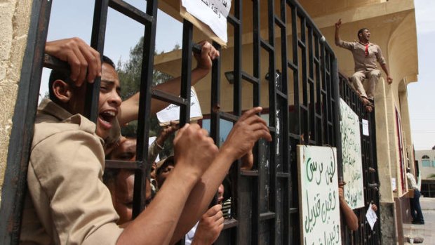 Egyptian border policemen shout at the closed Rafah border crossing between Egypt and the Gaza strip to protest the abduction of their colleagues in Rafah, Sinai,