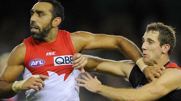 Adam Goodes pushes off Essendon's Kyle Hardingham.