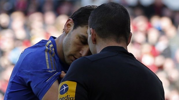 Chelsea's Branislav Ivanovic (left) shows the bite marks on his arm to referee Kevin Friend left by Luis Suarez.