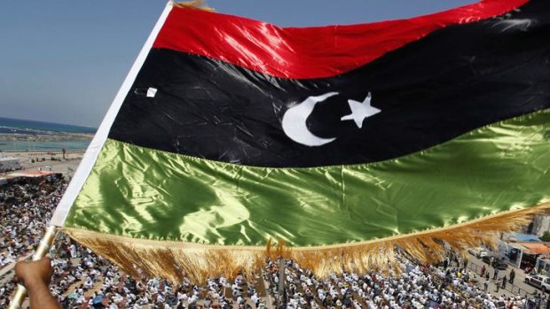 Renewed ... a Libyan waves the pre-Gaddafi Kingdom of Libya flag during Friday prayers.