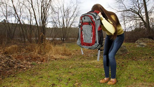 Amanda Curran, 18, daughter of Bullet Blocker inventor Joe Curran, demonstrates how to use a child's bulletproof backpack.