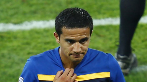 A dejected Tim Cahill walks off the pitch after getting a red card.