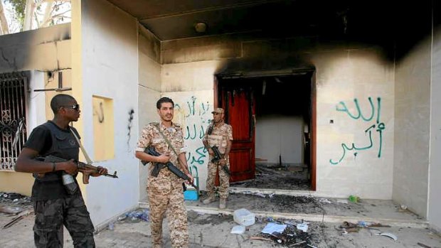 Libyan military guards check one of the US mission's burnt-out buildings in September.