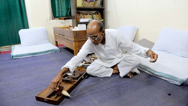 Ashram co-ordinator Rameshbhai Trivedi prepares cotton thread on a manual 'charkha' or a weaving tool inside his office at Kochrab Ashram, Mahatma Gandhi's most famous ashram and site of the 'Live Gandhi for a While' program.