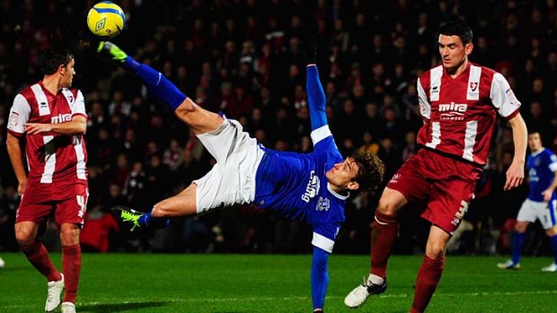 Nikica Jelavic of Everton attempts an overhead kick as Billy Jones of Cheltenham Town (right) looks on.