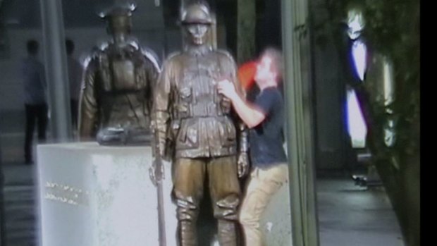 A traffic cone was placed on top of statue's helmet.
