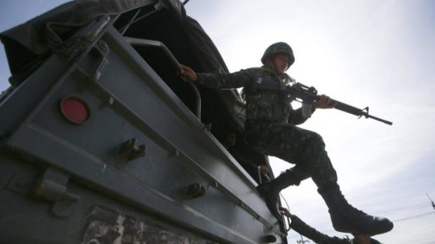 A Thai soldier jumps arrives at a pro-government rally site on the outskirts of Bangkok.