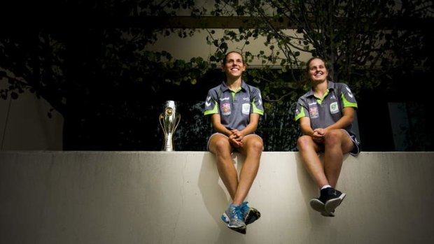 Canberra United players Nicole Sykes and Ellie Brush with the 2012 W-League trophy ahead of their semi-final against Brisbane this weekend.