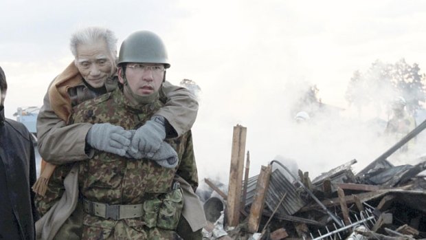 An elderly man is being carried by Self-Defense Force member in the tsunami-torn Natori city.