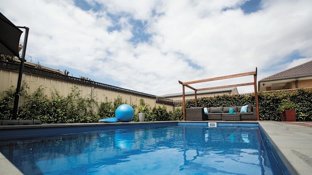 A swimming pool was recently installed in the back garden, and the finishing touches are being put to some outdoor tiling. 