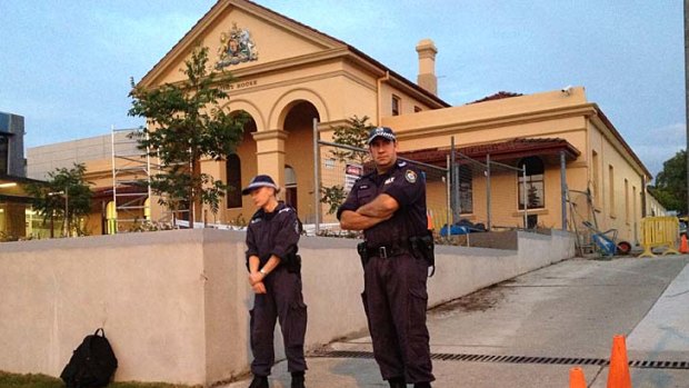 Arrested ... police stand guard outside Taree police station where Malcolm Naden is being held.