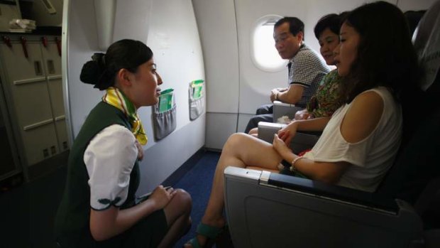 A crew member of Spring Airlines talks with travellers.