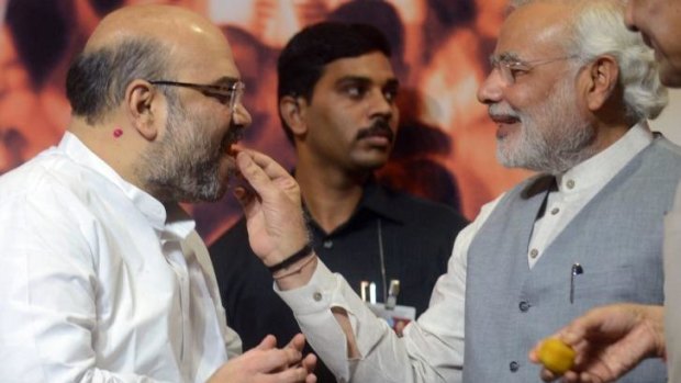 Indian Prime Minister Narendra Modi (right) gives sweets to newly appointed BJP president Amit Shah on Wednesday.