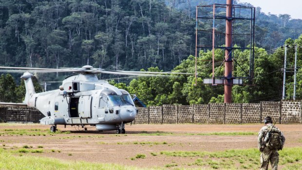A British helicopter lands on a football pitch in Freetown, Sierra Leone to deliver supplies to medical teams.