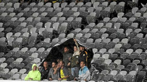 Where are you ... fans brave the wet weather during the match against the Victory.