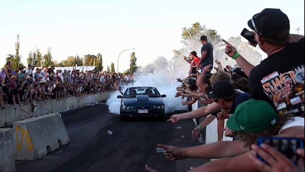 Smoke on the bitumen: Fans show their appreciation as a driver does a burnout in Canberra.