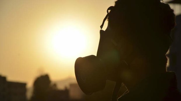 An activist wearing a gas mask is seen in Zamalka area, where activists say chemical weapons have been used.