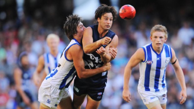 Prized scalp .... A North Melbourne player gets a firm grip of Geelong's Jimmy Bartel during their upset victory.