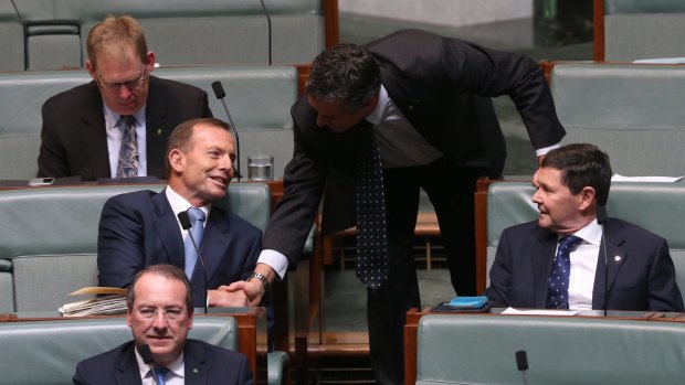 Backbencher Tony Abbott is welcomed by Darren Chester during question time at Parliament House.