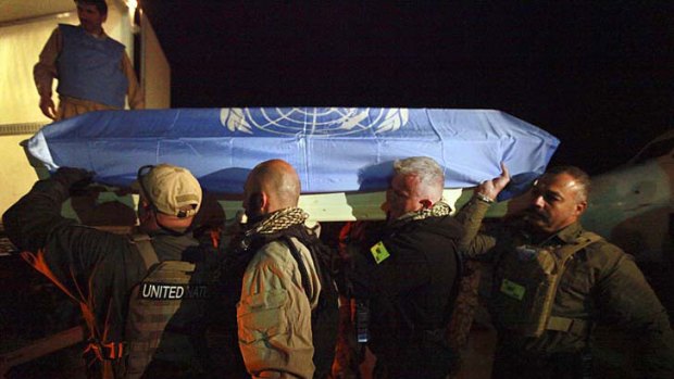 Laid to rest ... UN personnel carry the casket of a colleague killed in an attack on the UN operations centre in Mazar-e-Sharif.
