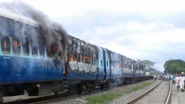 The aftermath: Train carriages of the Rajya Rani Express set on fire by an angry mob after it ploughed into a crowd of Hindu pilgrims at the Dhamara Ghat railway station.