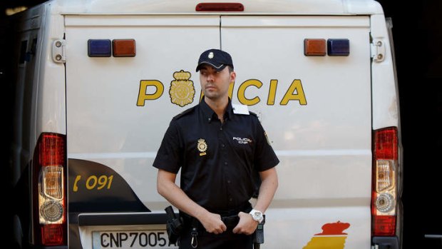 A policeman stands guard at a police van allegedly holding Brett and Naghemeh King at court in Madrid.