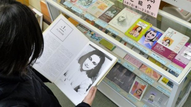 A woman holds one of the Anne Frank-related books donated to Tokyo libraries by Anne Frank House following the vandalism.
