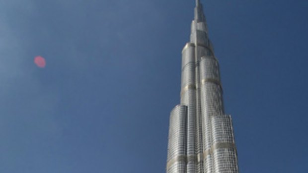 Emirati men walk past Burj Dubai, the world's tallest tower, in the Gulf emirate nation.  In an ambitious move, US department Bloomingdale's has opened in the tower.