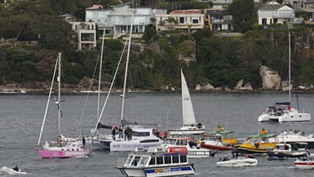 Jessica's Watson pink yacht makes its way out of Sydney Harbour yesterday surrounded by supporters and media.