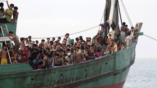 Rohingya and Bangleshi migrants wait on board a fishing boat before being transported to shore, off the coast of Julok, in Aceh province.