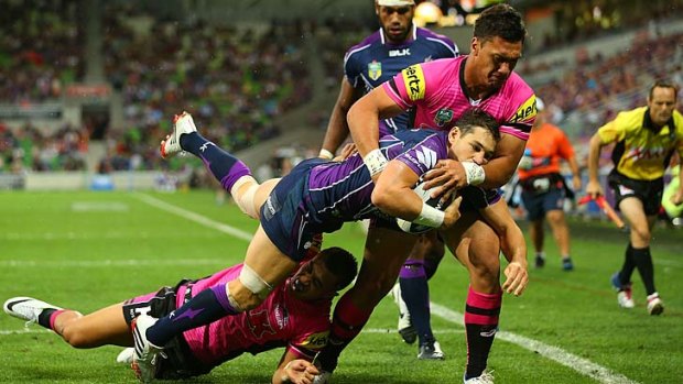 Coming to grips: Storm fullback Billy Slater is stopped in his tracks by Panther Elijah Taylor.