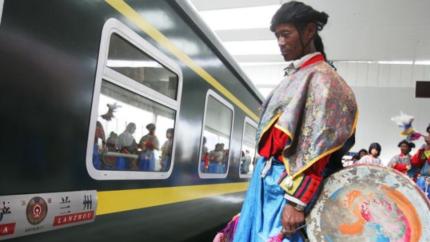 A man in traditional dress waits at the platform.