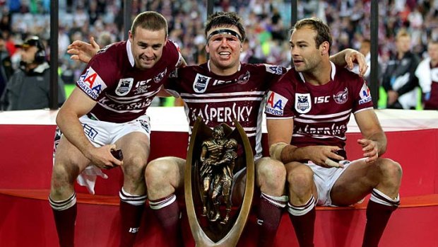 Michael Robertson, Jamie Lyon and Brett Stewart of the Sea Eagles celebrate with the premiership trophy.