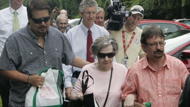 Powerball winner Gloria C. Mackenzie, 84, leaves the lottery office escorted by her son Scott Mackenzie, right, after claiming a single lump-sum payment of about $US370.9 million before taxes in Tallahassee, Florida.