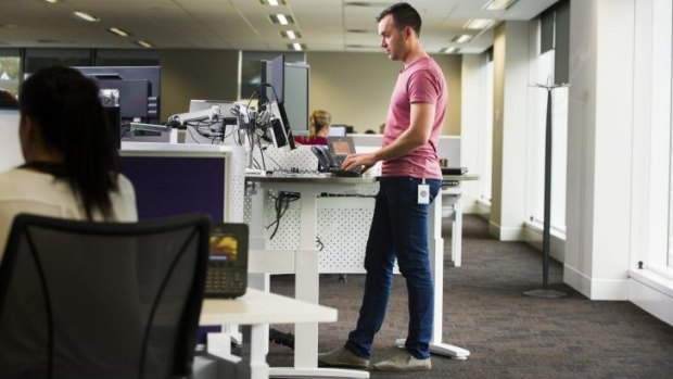 PwC consultant Tom Simmonds using a standup desk. No one now has an individual space that is theirs.
