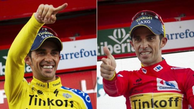 Tinkoff's Spanish cyclist Alberto Contador celebrating on the podium after retaining the red jersey (R) and winning the 16th stage.