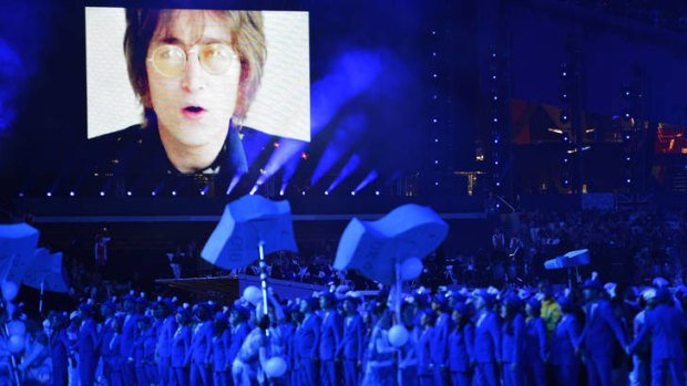 Athletes parade as the image of the late British rock singer and composer John Lennon is projected to the sounds of his song "Imagine".
