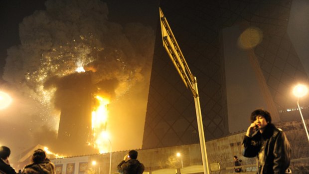 New year disaster ... people gather to watch the fire engulfing the Mandarin Oriental hotel in Beijing, part of the architecturally celebrated CCTV complex.