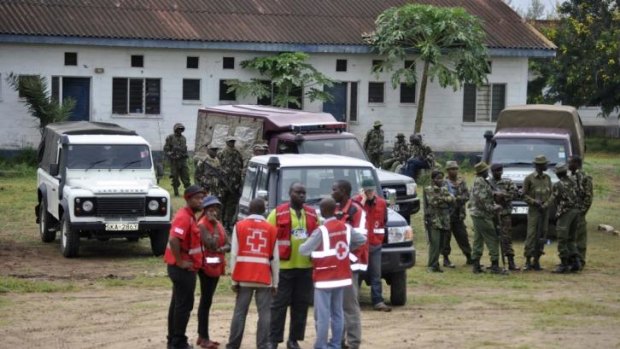 Security personnel and Kenya Red Cross officials stand at one of the sites where the attacks took place.