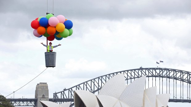 Opera Australia artistic director Lyndon Terracini rides in a garbage can under a balloon canopy over Sydney Harbour as he stands in for the character Parpignol during a test run of the prop for Puccini's La Boheme opera in Sydney. The production of La Boheme is set in a wintry 1960s Parisian landscape.