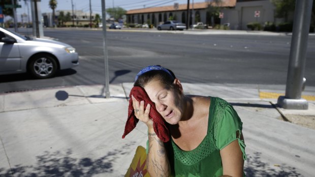 Amanda Ouellet wipes her face with a cold wet towel to cool off in Las Vegas on July 1, 2014.