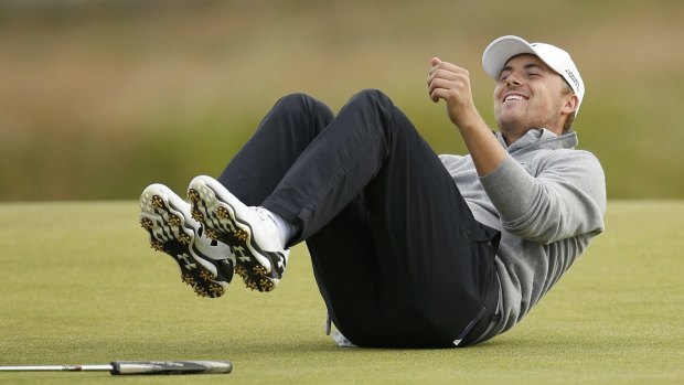 Having a laugh: Jordan Spieth laughs as he sits on the fifth green during his practice round.