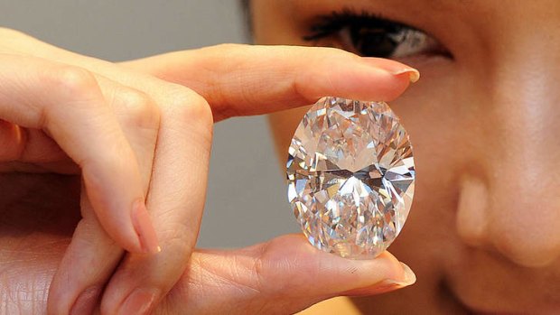 A model holds a flawless oval diamond during a media preview at Sotheby's auction house in Hong Kong.